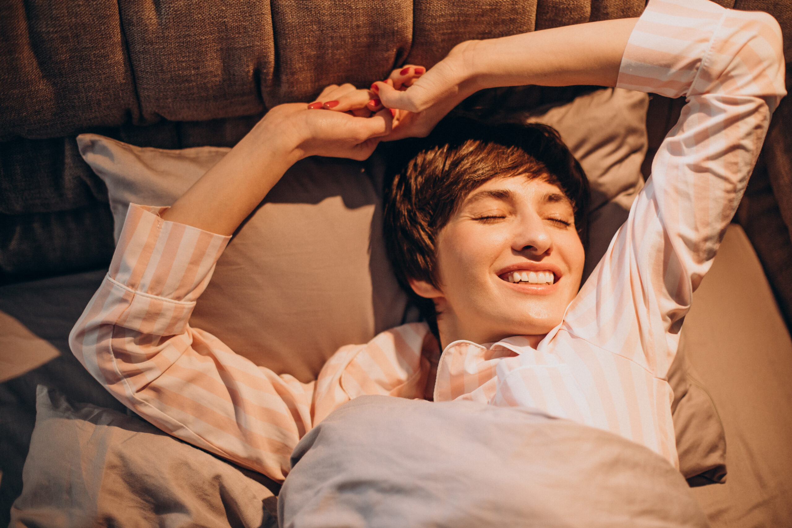 Woman in pajamas waking up in bed