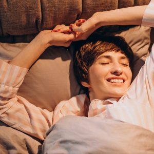 Woman in pajamas waking up in bed